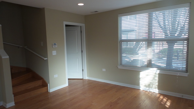1244 West Monroe Street, Unit 1 Chicago, IL 60607 - Photo 4 of 25 a view of empty room with wooden floor and fan