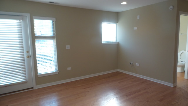 1244 West Monroe Street, Unit 1 Chicago, IL 60607 - Photo 6 of 25 an empty room with wooden floor and windows