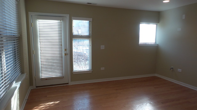 1244 West Monroe Street, Unit 1 Chicago, IL 60607 - Photo 7 of 25 an empty room with wooden floor and windows