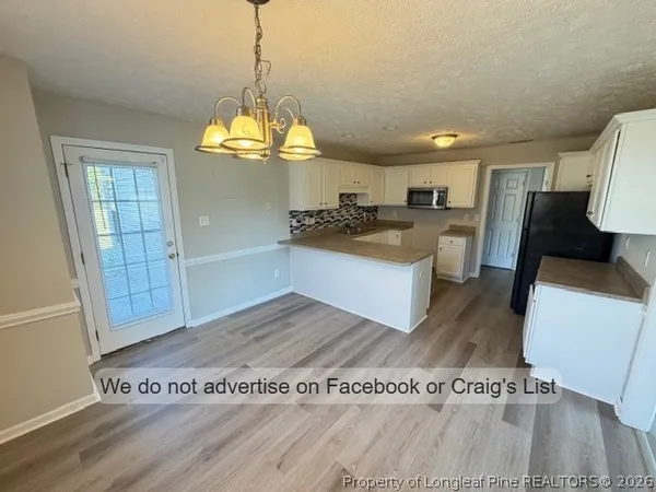 a view of a kitchen with stainless steel appliances granite countertop a refrigerator and a stove top oven
