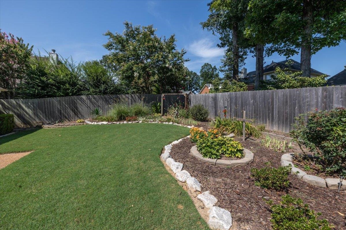 3169 Hedgemore Cove Bartlett, TN 38135 - Photo 29 of 31 a view of a backyard with a small fountain plants and wooden fence