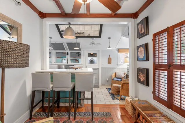 a living room with furniture a chandelier and a dining table with wooden floor