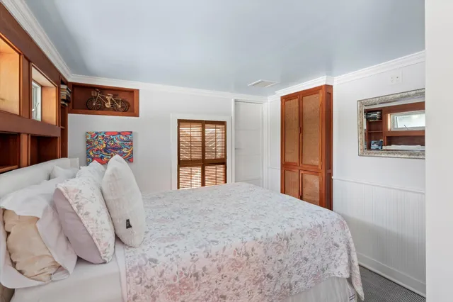 a large bed sitting in a bedroom next to a large window