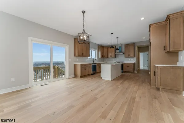 a kitchen with stainless steel appliances granite countertop a sink a stove and a wooden floors