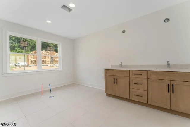 a spacious bathroom with a granite countertop sink mirror and window