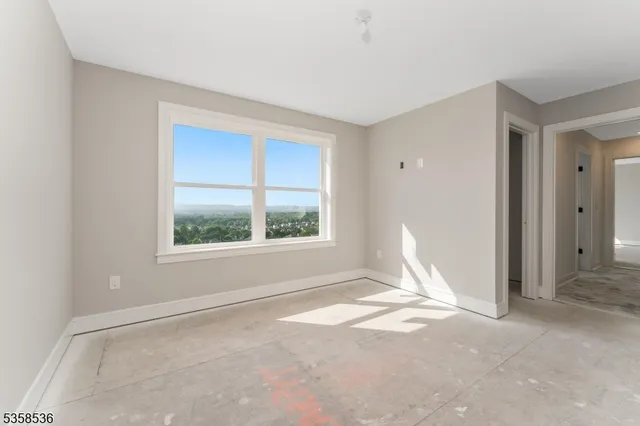 a view of a big room with windows and chandelier fan