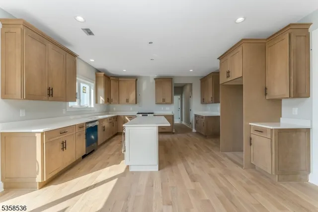 a kitchen with a sink a counter top space stainless steel appliances cabinets and a window