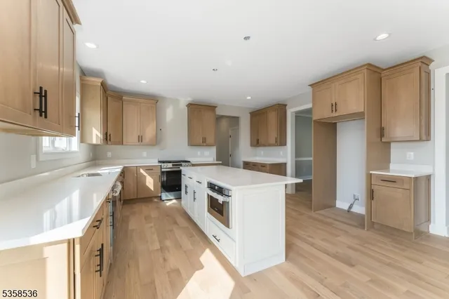 a kitchen with stainless steel appliances granite countertop a stove a sink and a refrigerator