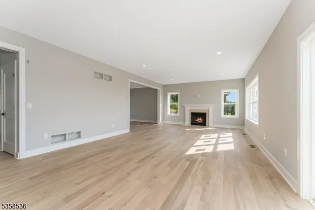 an empty room with wooden floor and fireplace