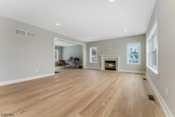 a open kitchen with a refrigerator a oven and a wooden floor