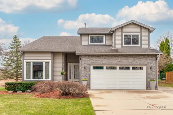 a front view of a house with a yard and garage