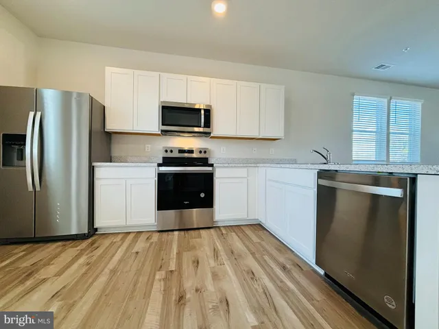 a kitchen with stainless steel appliances a refrigerator sink and microwave