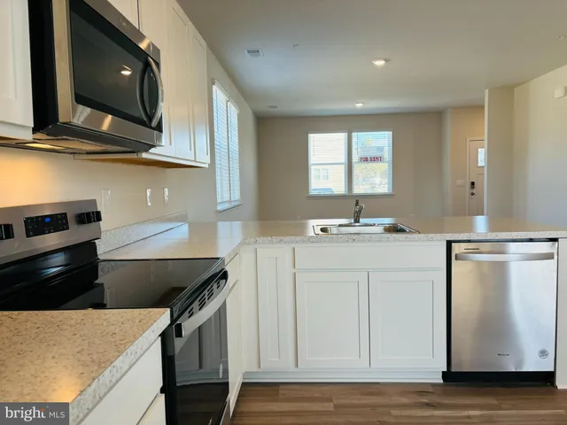 a kitchen with stainless steel appliances granite countertop a sink and a stove