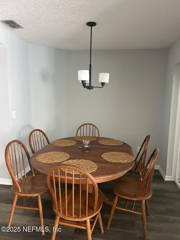 a view of a dining room with furniture wooden floor and white walls