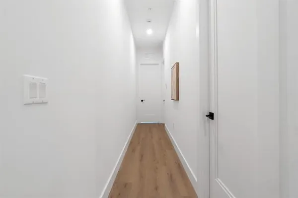 a view of a hallway with wooden floor
