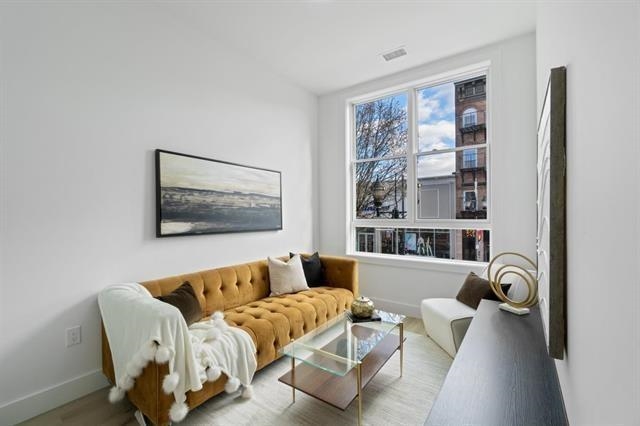491 Broadway, Unit 202 Bayonne, NJ 07002 - Photo 16 of 20 a living room with furniture and a large window
