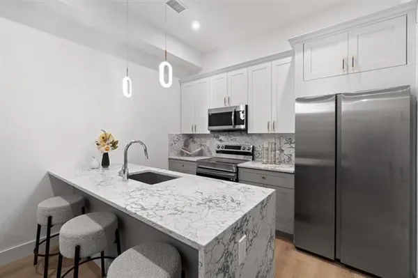 a kitchen with kitchen island a refrigerator stove microwave and cabinets