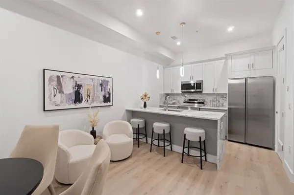 a kitchen with stainless steel appliances granite countertop a white refrigerator a microwave a sink and white cabinets
