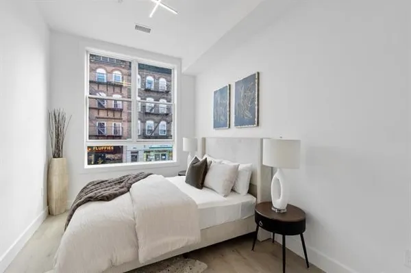 a bedroom with bed and wooden floor