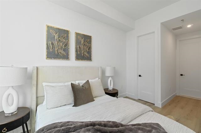 491 Broadway, Unit 202 Bayonne, NJ 07002 - Photo 9 of 20 a bedroom with a bed and painting on the wall