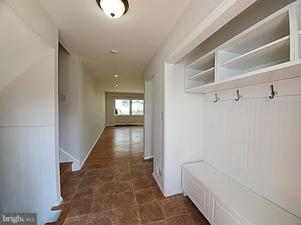 a hallway with white doors wooden floor and stairs