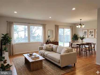 a living room with furniture a wooden floor and a large window