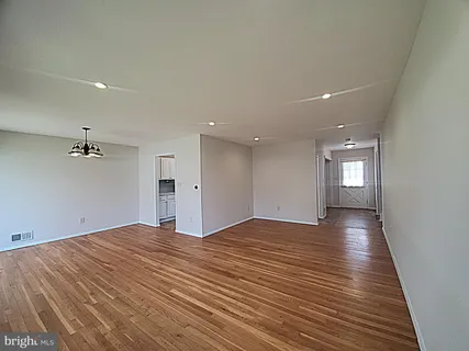 a view of empty room with wooden floor and window