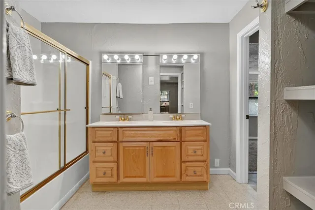 a spacious bathroom with a granite countertop sink a mirror and a shower