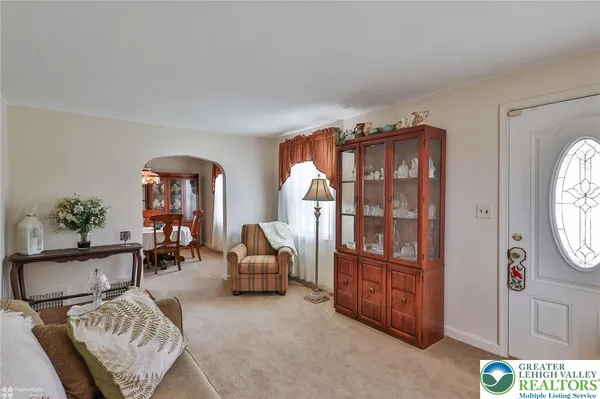 a living room with furniture a chandelier and a dining table