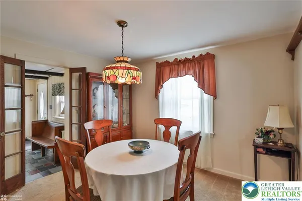 a dining room with furniture a chandelier and window