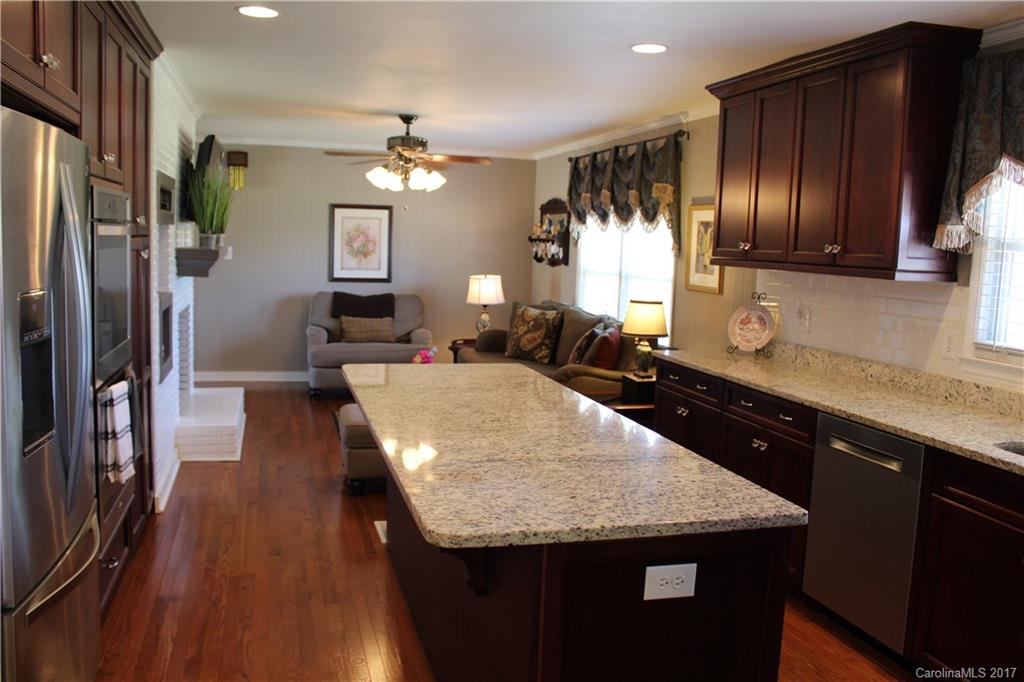 3304 Wolf Pond Road Monroe, NC 28112 - Photo 3 of 17 a kitchen with granite countertop stainless steel appliances a sink stove top oven and cabinets