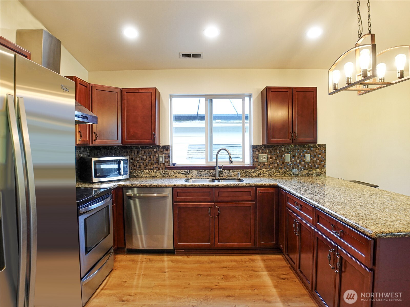 5451 32nd Avenue Southwest Seattle, WA 98126 - Photo 20 of 34 a kitchen with stainless steel appliances granite countertop a sink stove and refrigerator