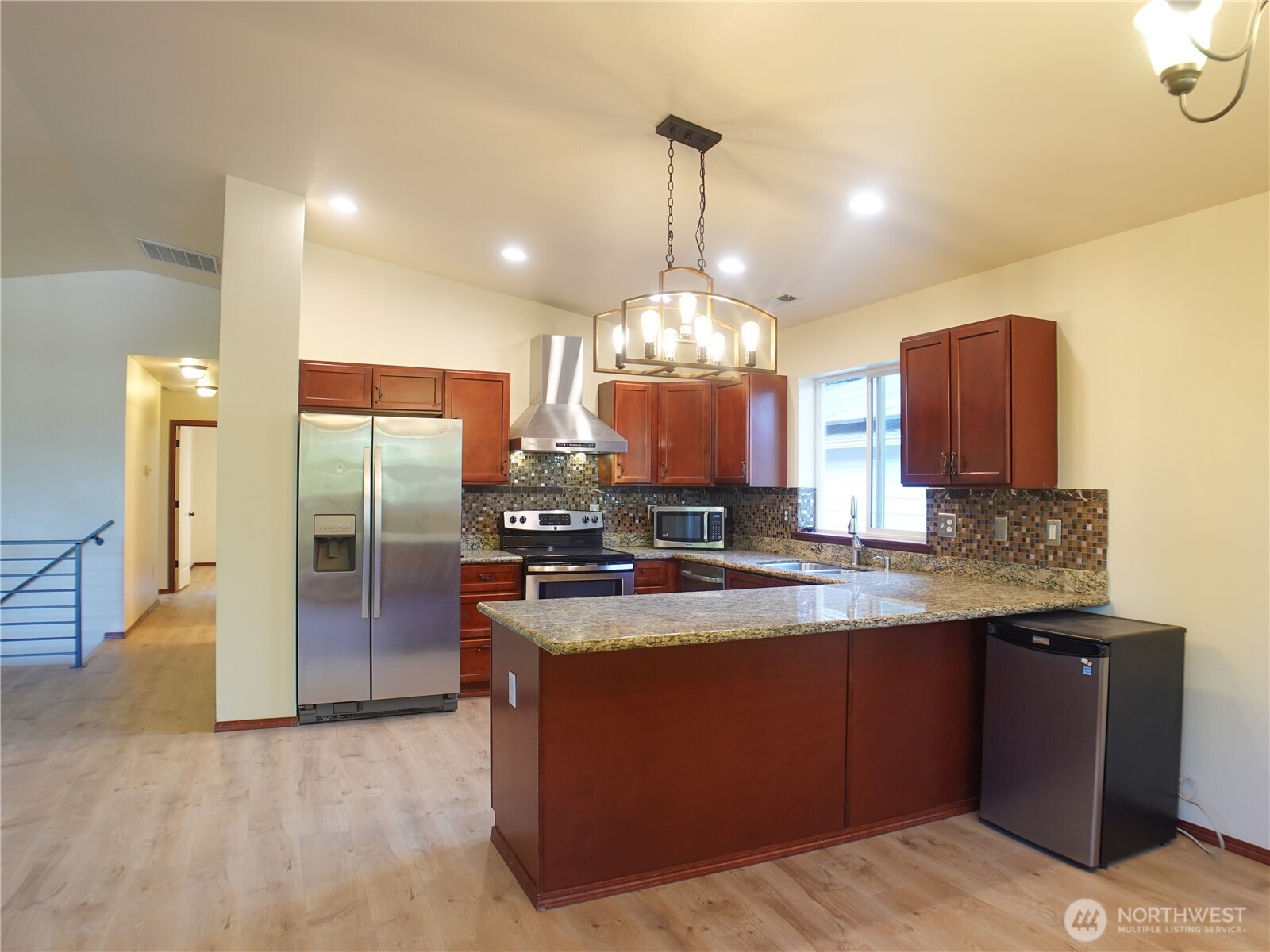 5451 32nd Avenue Southwest Seattle, WA 98126 - Photo 22 of 34 a kitchen with stainless steel appliances granite countertop a sink a stove and a refrigerator