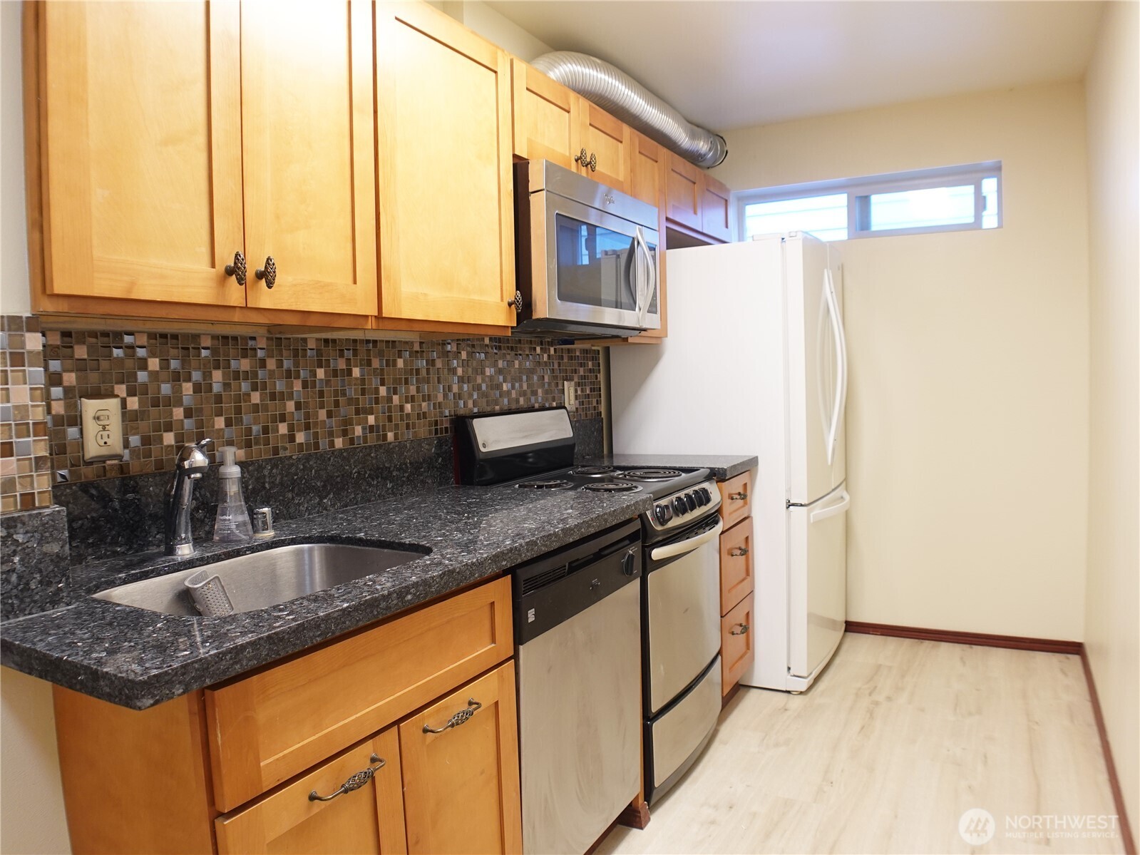 5451 32nd Avenue Southwest Seattle, WA 98126 - Photo 24 of 34 a kitchen with granite countertop a sink and a refrigerator
