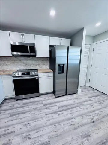 a kitchen with stainless steel appliances granite countertop a stove a refrigerator and a microwave