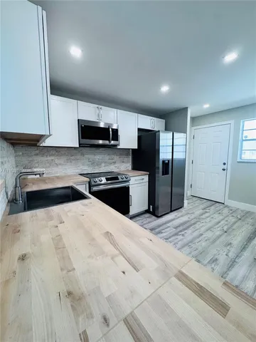 a kitchen with stainless steel appliances kitchen island granite countertop a refrigerator sink and stove