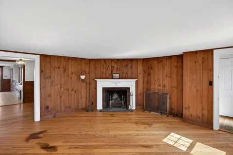 a view of empty room with wooden floor and fireplace