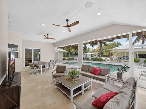 a living room with furniture a rug and a floor to ceiling window