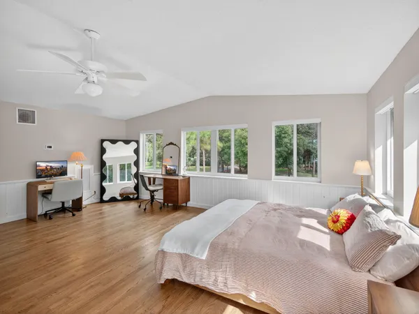 a bedroom with furniture and a large window