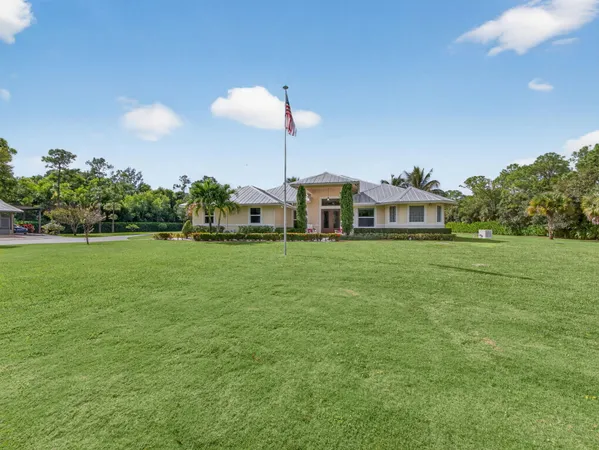 a view of a house with a big yard and potted plants
