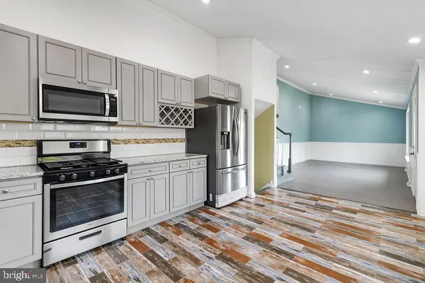 a kitchen with stainless steel appliances granite countertop a stove a refrigerator and a microwave