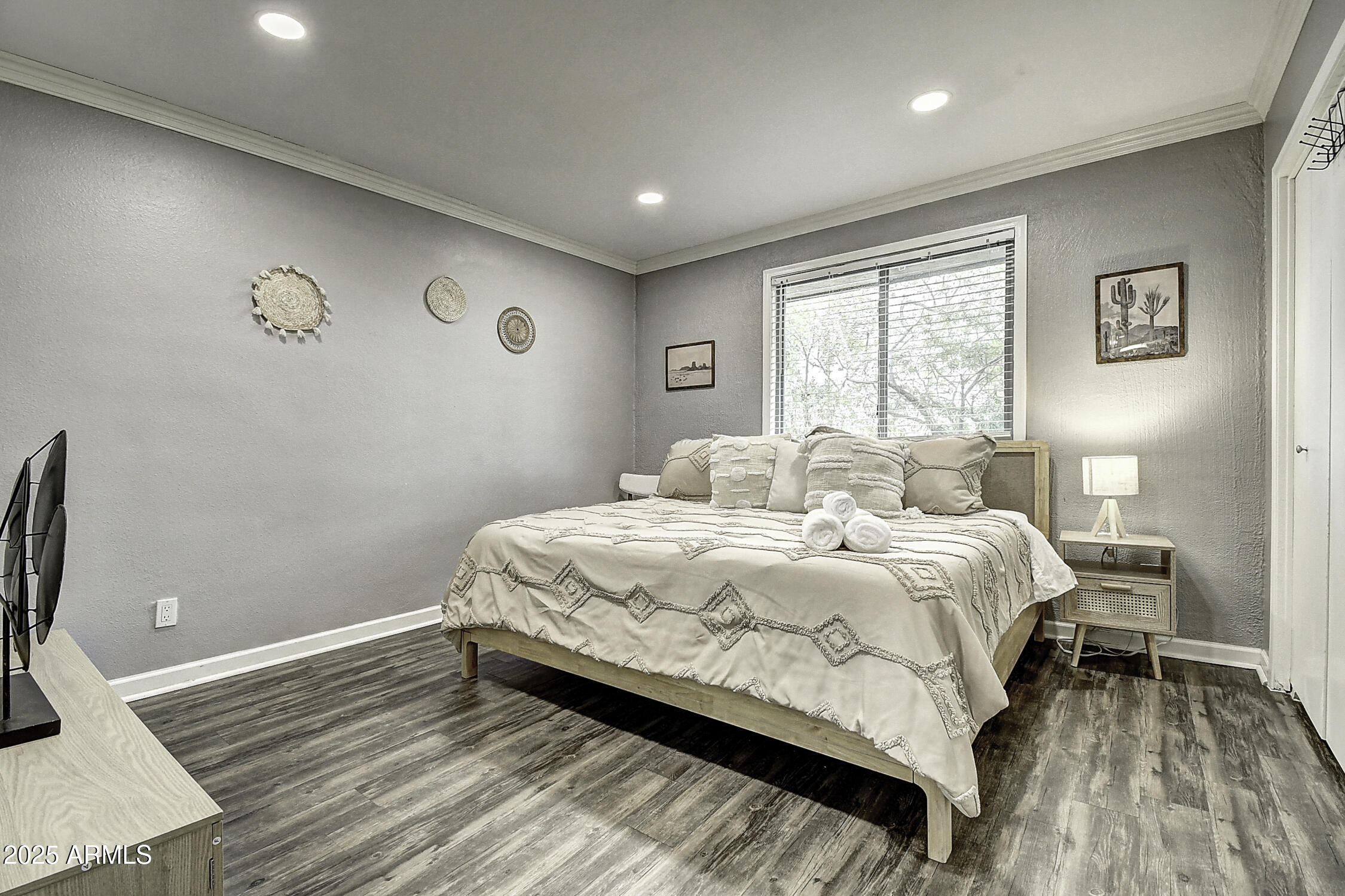 7625 East Camelback Road, Unit B203 Scottsdale, AZ 85251 - Photo 24 of 29 a bedroom with a bed and wooden floor