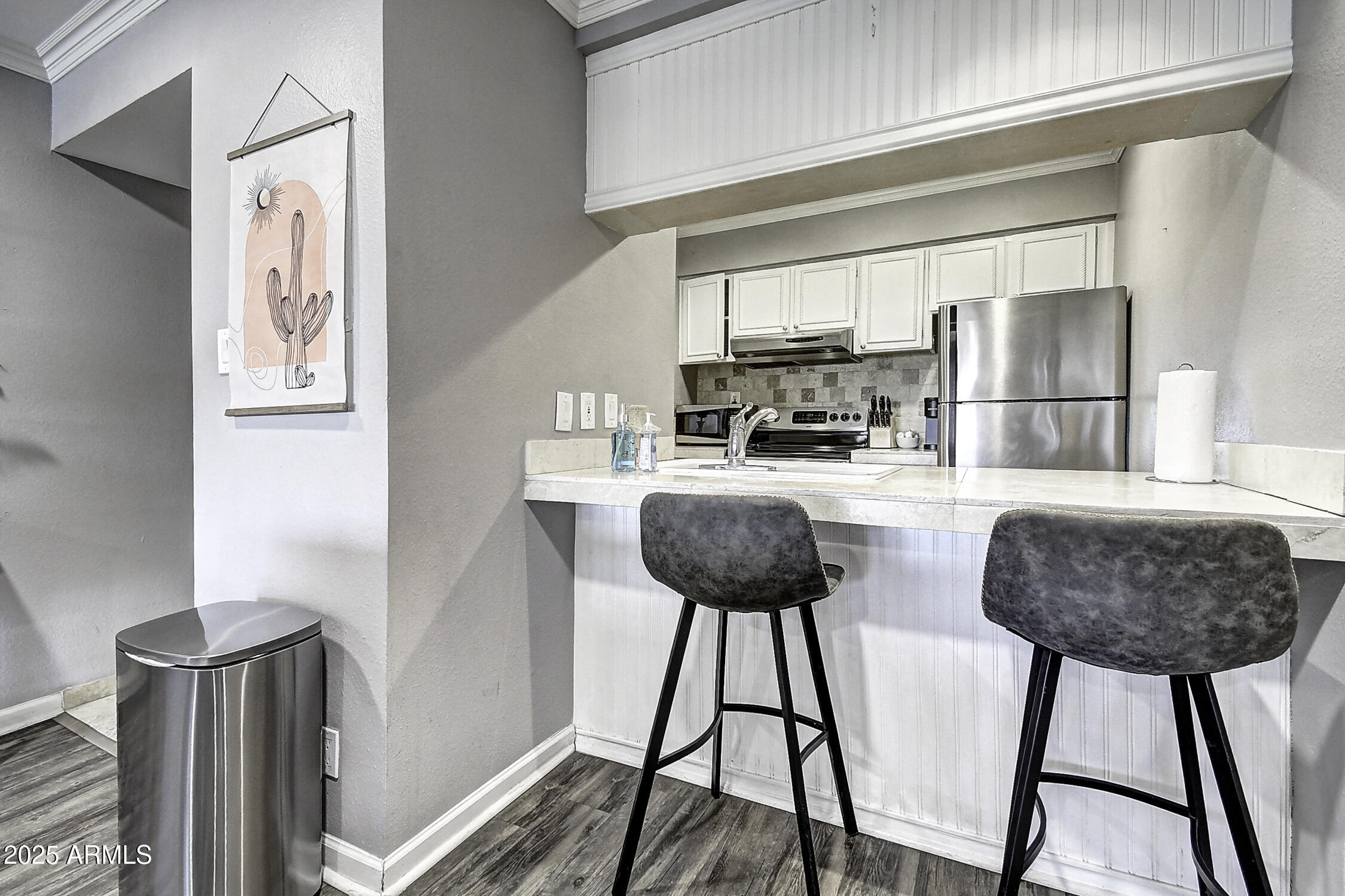 7625 East Camelback Road, Unit B203 Scottsdale, AZ 85251 - Photo 7 of 29 a kitchen with stainless steel appliances kitchen island a table and chairs in it