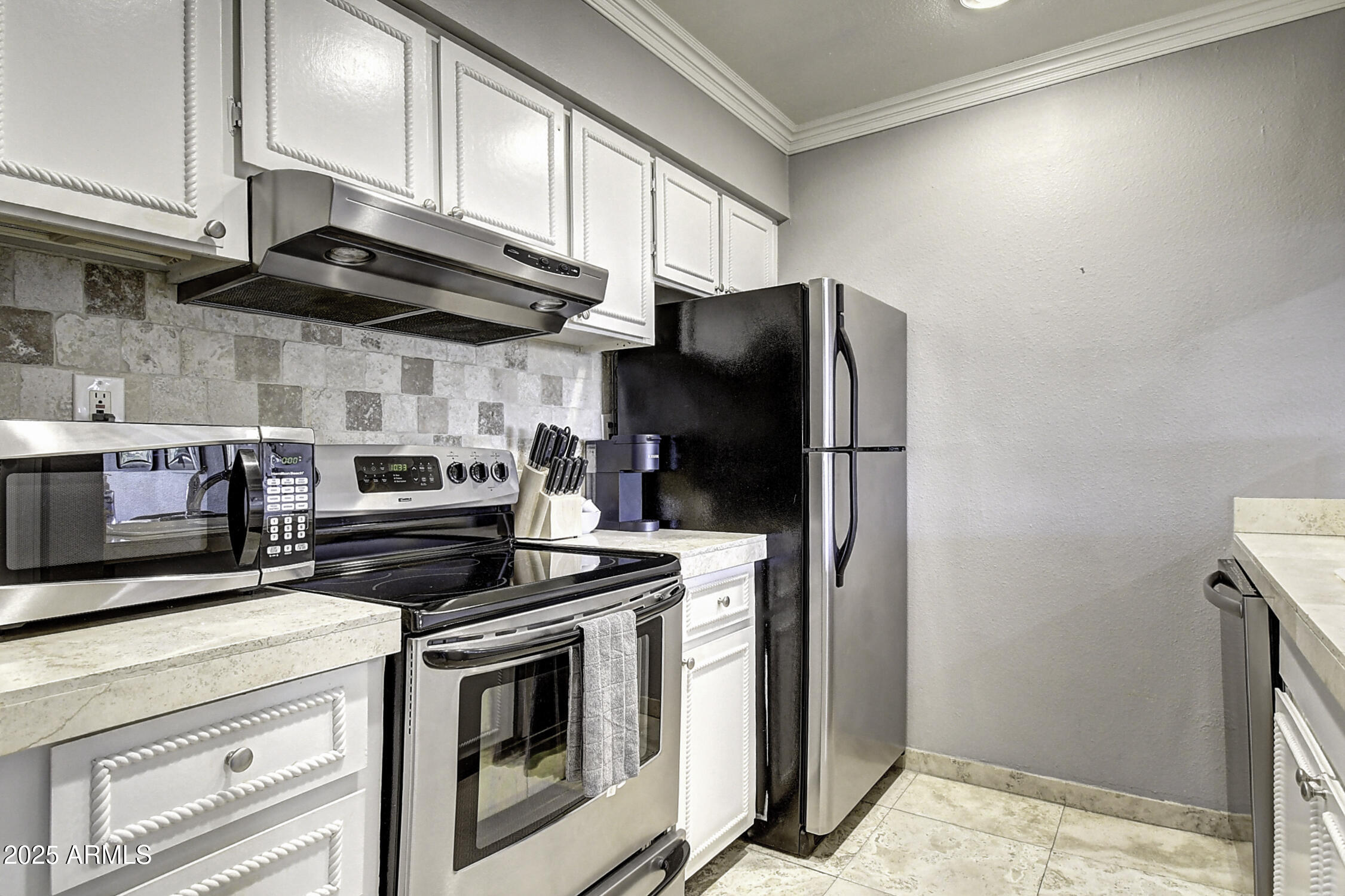 7625 East Camelback Road, Unit B203 Scottsdale, AZ 85251 - Photo 9 of 29 a kitchen with stainless steel appliances granite countertop a stove a refrigerator and a microwave