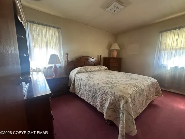 a bed sitting in a bedroom next to a window