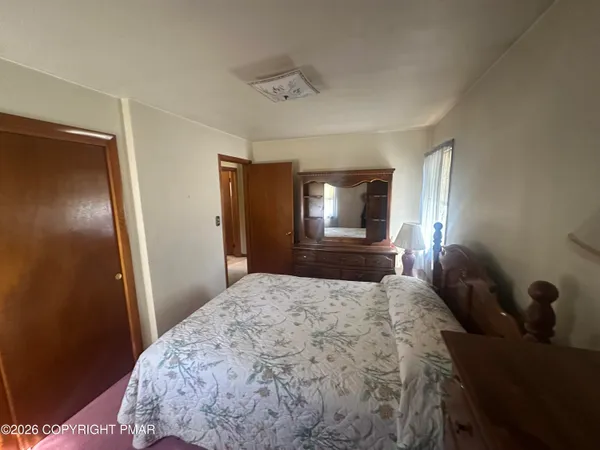 a bedroom with a bed and a mirror on dresser