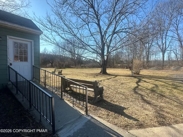 a view of a yard with wooden fence
