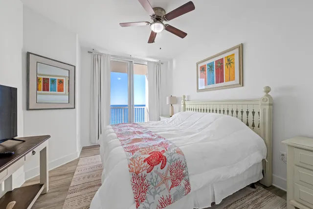 a bedroom with a bed and a flat tv screen on dresser