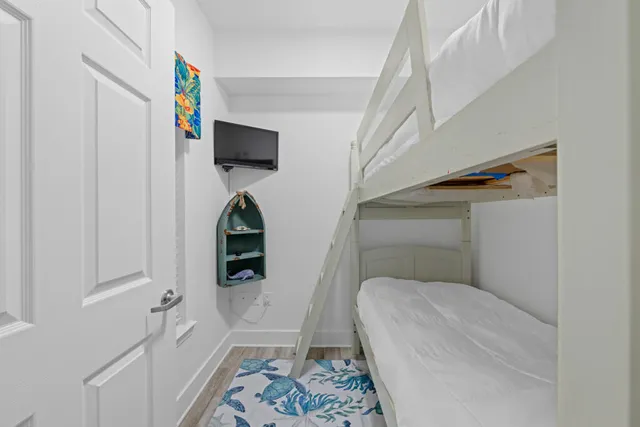 a bedroom with a bed and a flat tv screen on wall