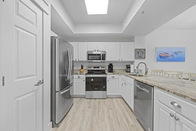a kitchen with appliances a sink and cabinets